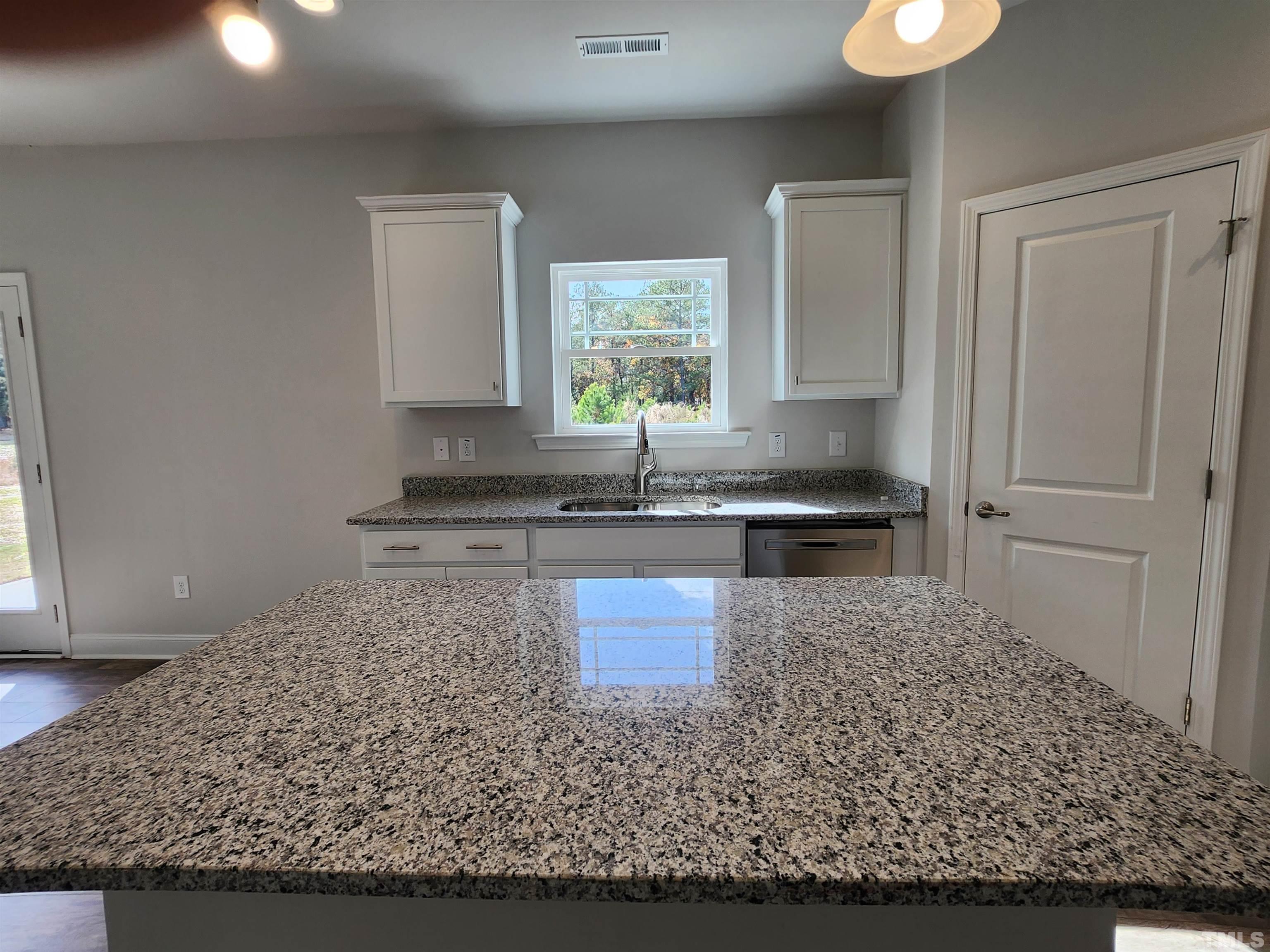 243 Spring Flowers Drive Cameron, NC 28326 - Photo 8 of 30 a kitchen with stainless steel appliances granite countertop a stove a sink and a microwave