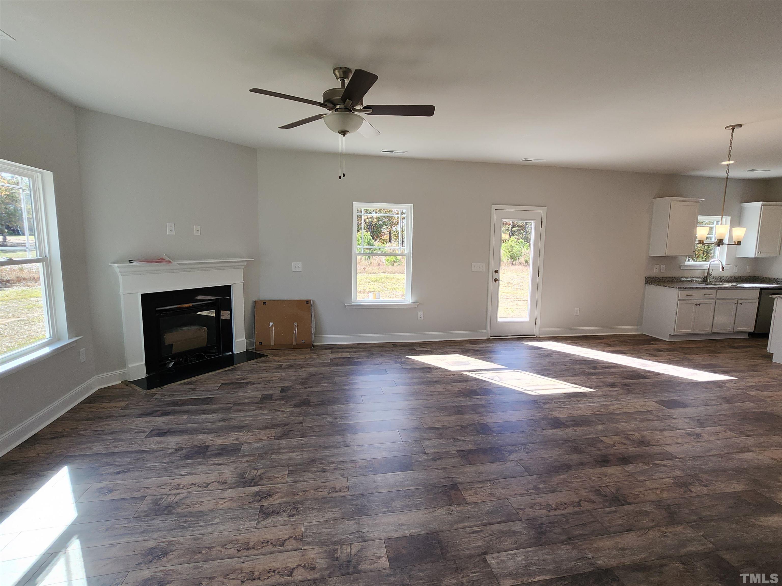243 Spring Flowers Drive Cameron, NC 28326 - Photo 10 of 30 a view of empty room with wooden floor and fireplace