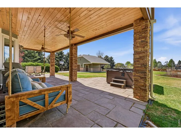 a view of a swimming pool with a couches and chairs under an umbrella
