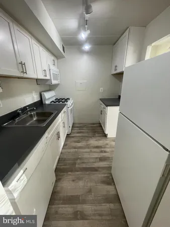 a kitchen with a sink a stove and cabinets