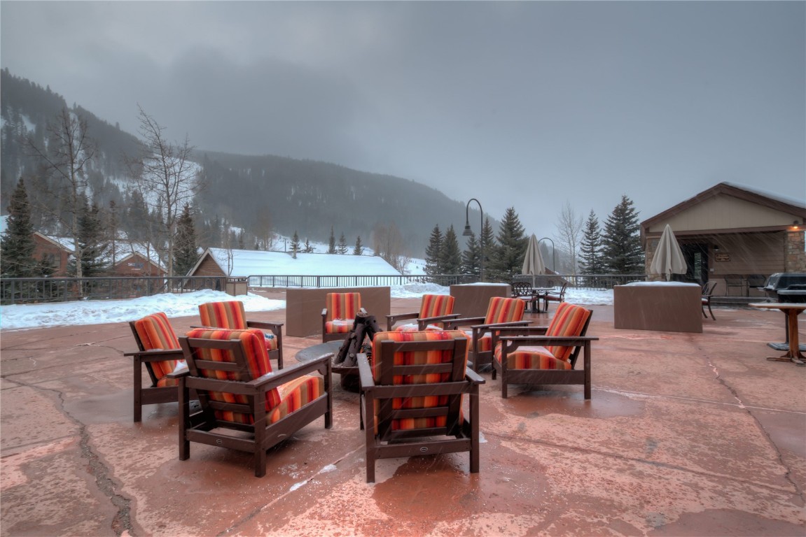 1211 West Keystone Road, Unit 2768 Keystone, CO 80435 - Photo 22 of 24 Patio with an outdoor fire pit and a mountain view. Clubhouse in the background