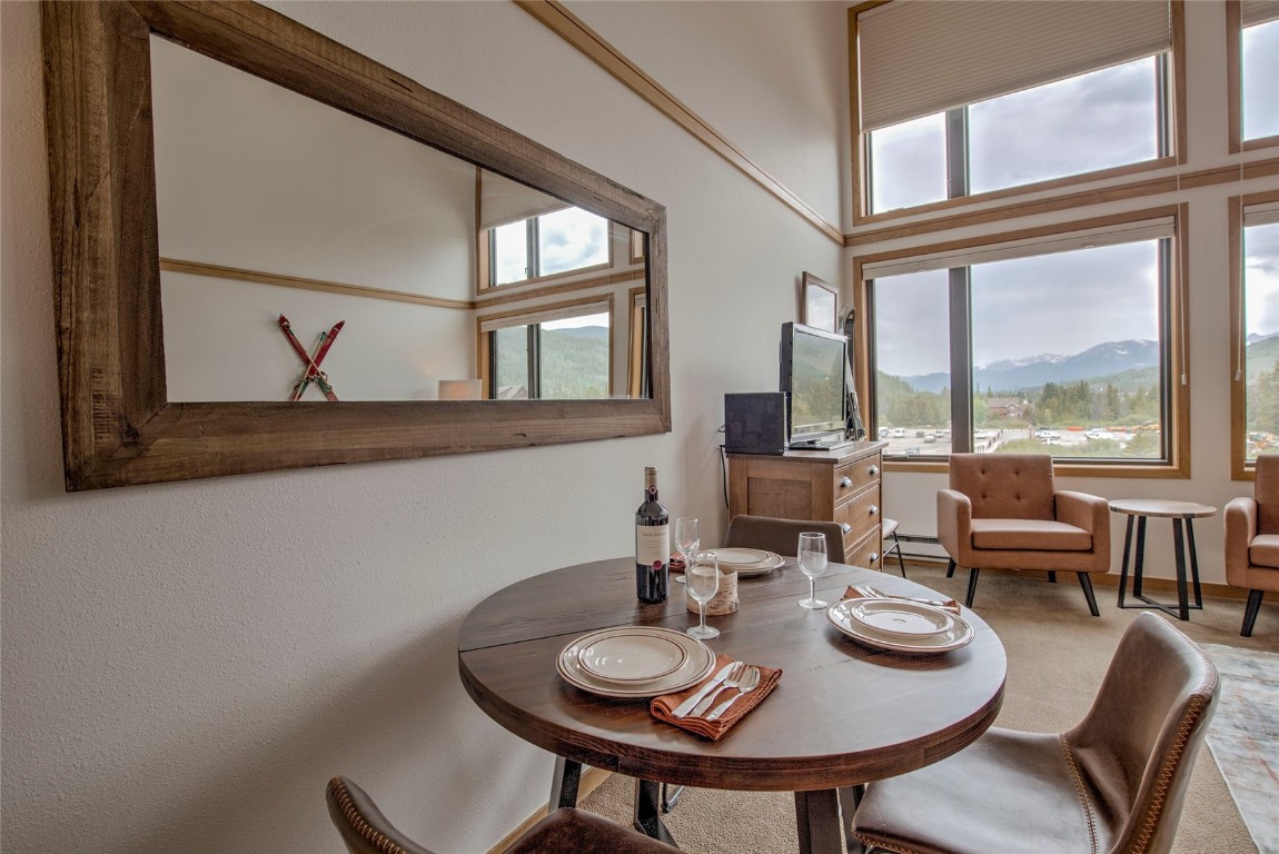 Dining area with a mountain view, a towering ceiling, and a healthy amount of sunlight