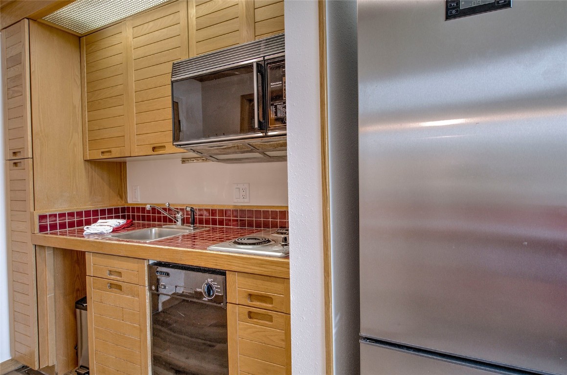 1211 West Keystone Road, Unit 2768 Keystone, CO 80435 - Photo 9 of 24 Kitchenette with Dishwasher, Cooktop, Microwave and a full size refrigerator. Fully equipped with cookware, dinnerware, and essential small appliances.