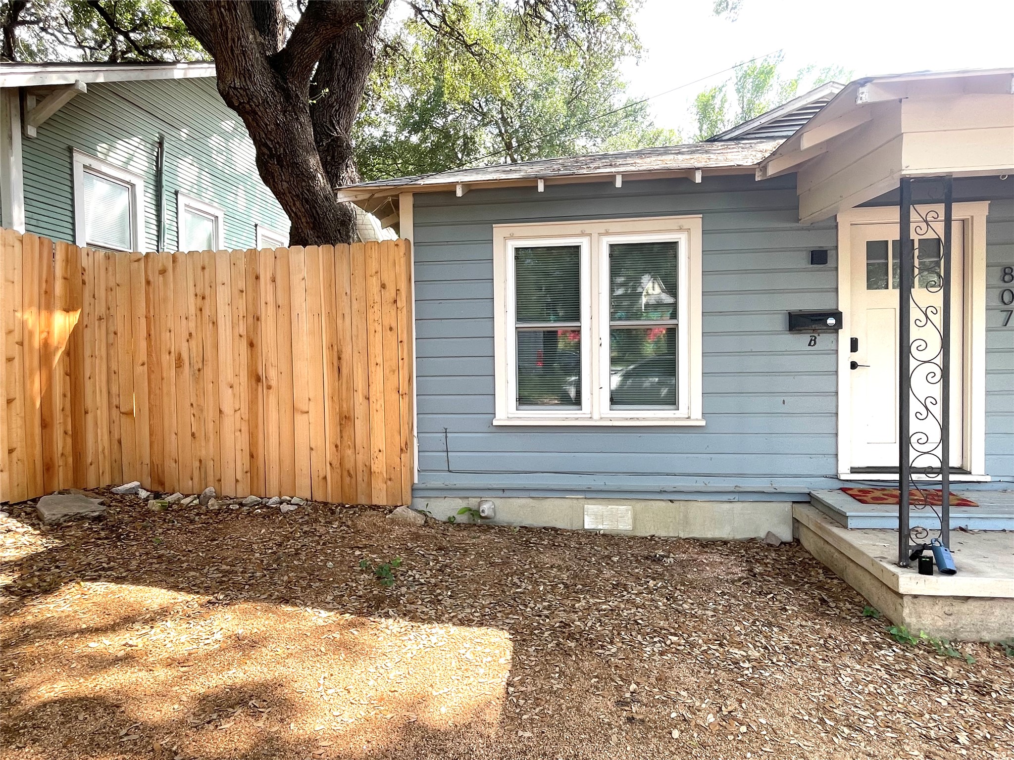 807 East Riverside Drive, Unit B Austin, TX 78704 - Photo 2 of 28 A charming home entrance boasts a classic porch and a newly installed privacy fence.
