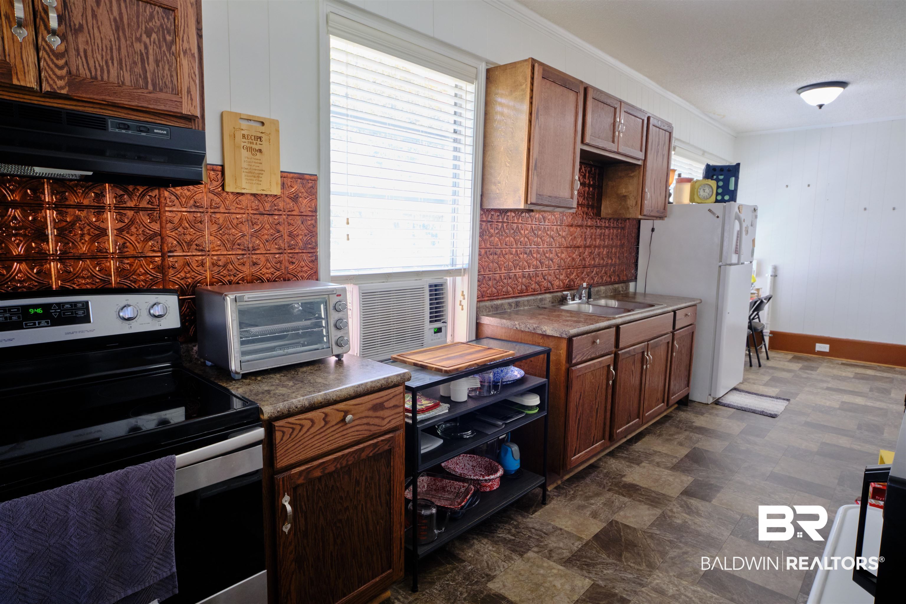 101 West Horner Street Atmore, AL 36502 - Photo 25 of 38 Kitchen featuring electric stove, white refrigerator, sink, dark tile patterned flooring, and ornamental molding