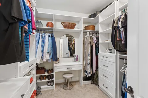 a view of walk in closet with clothes and shoes
