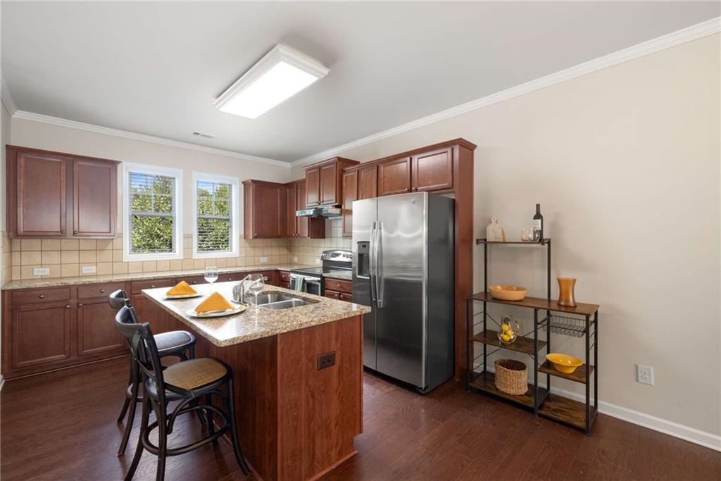 3084 Turman Circle Decatur, GA 30033 - Photo 7 of 36 a kitchen with stainless steel appliances granite countertop a refrigerator a sink a stove and white cabinets with wooden floor