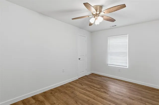 an empty room with a window and a fan