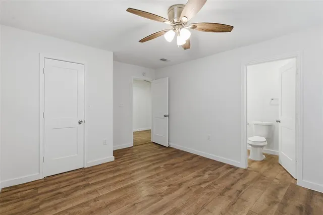 a view of a room with wooden floor and ceiling fan