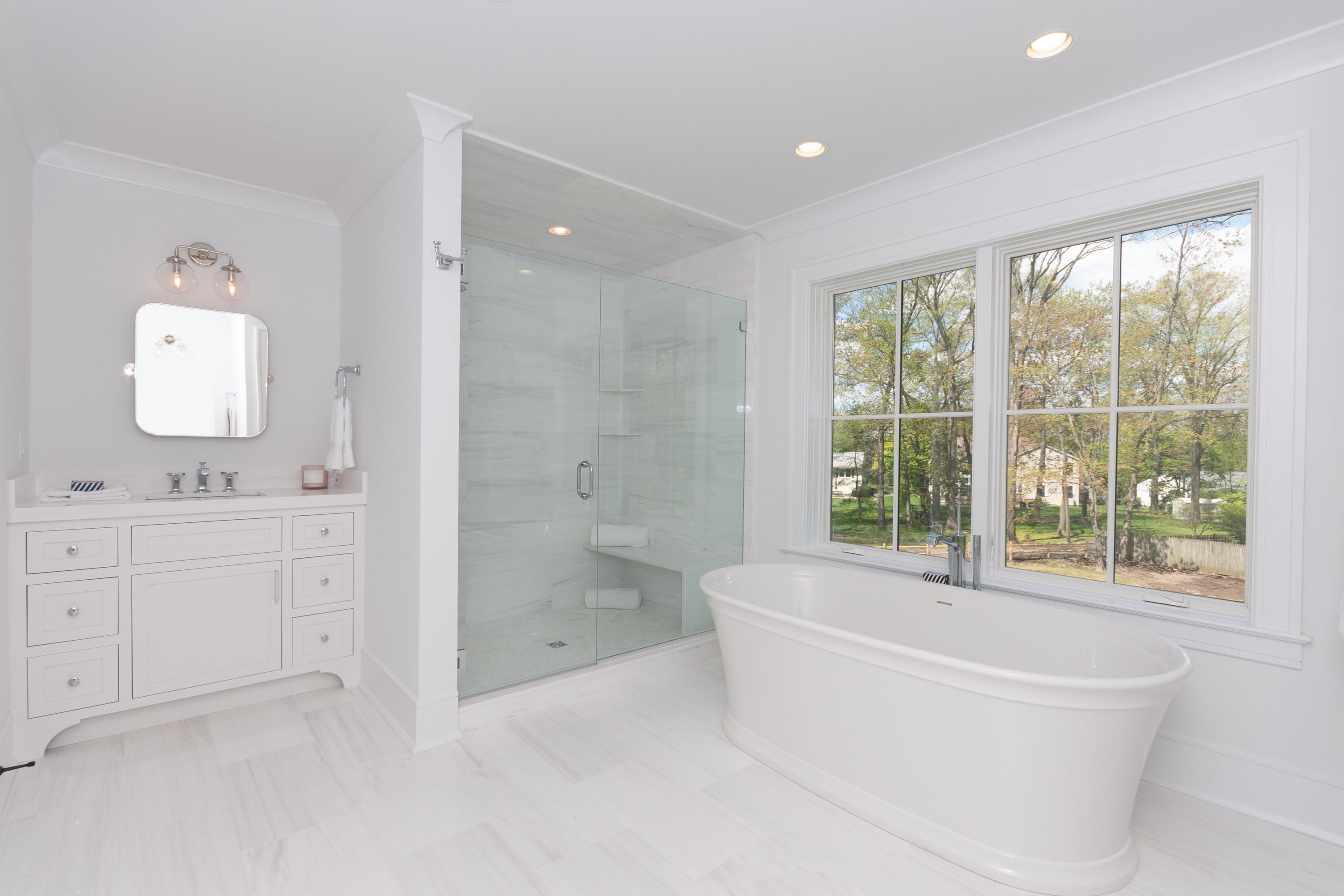 113 Hollow Tree Ridge Road Darien, CT 06820 - Photo 25 of 48 a bathroom with a bathtub a sink a large mirror and a shower