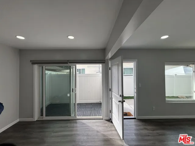 an empty room with wooden floor & windows