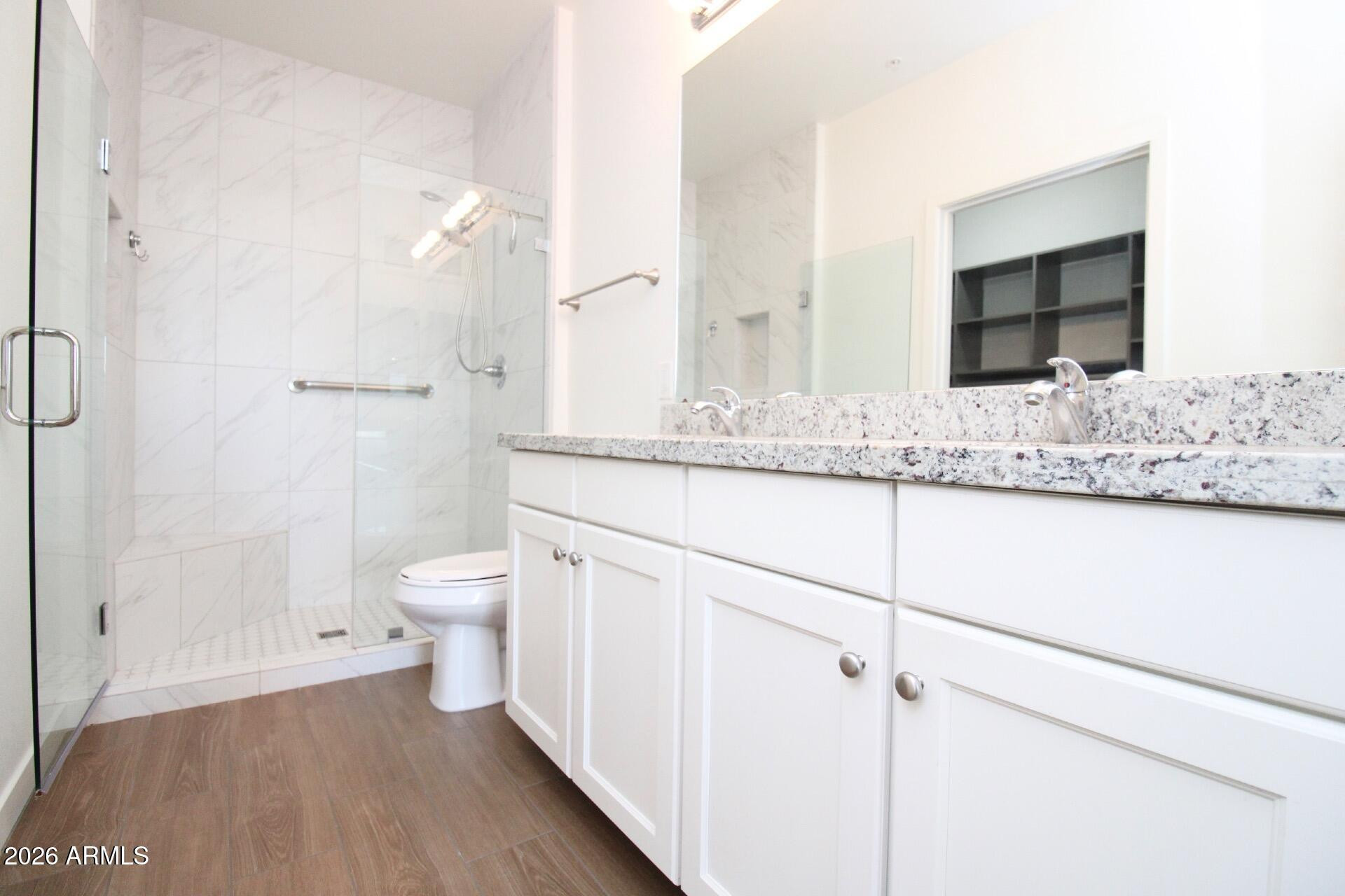 2511 West Queen Creek Road, Unit 438 Chandler, AZ 85248 - Photo 12 of 23 a bathroom with a granite countertop sink mirror vanity and toilet