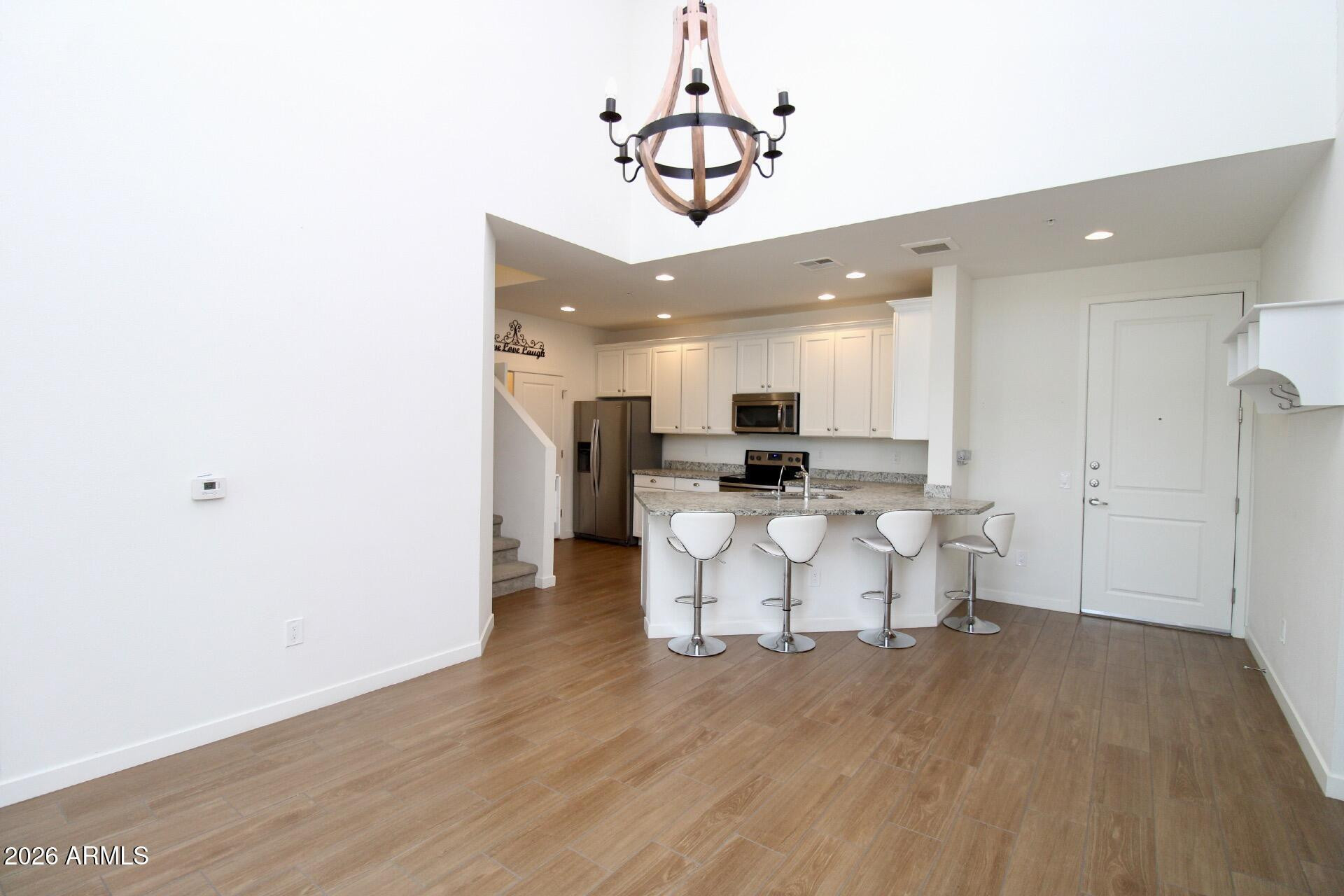 2511 West Queen Creek Road, Unit 438 Chandler, AZ 85248 - Photo 3 of 23 a view of a dining room with furniture and a chandelier