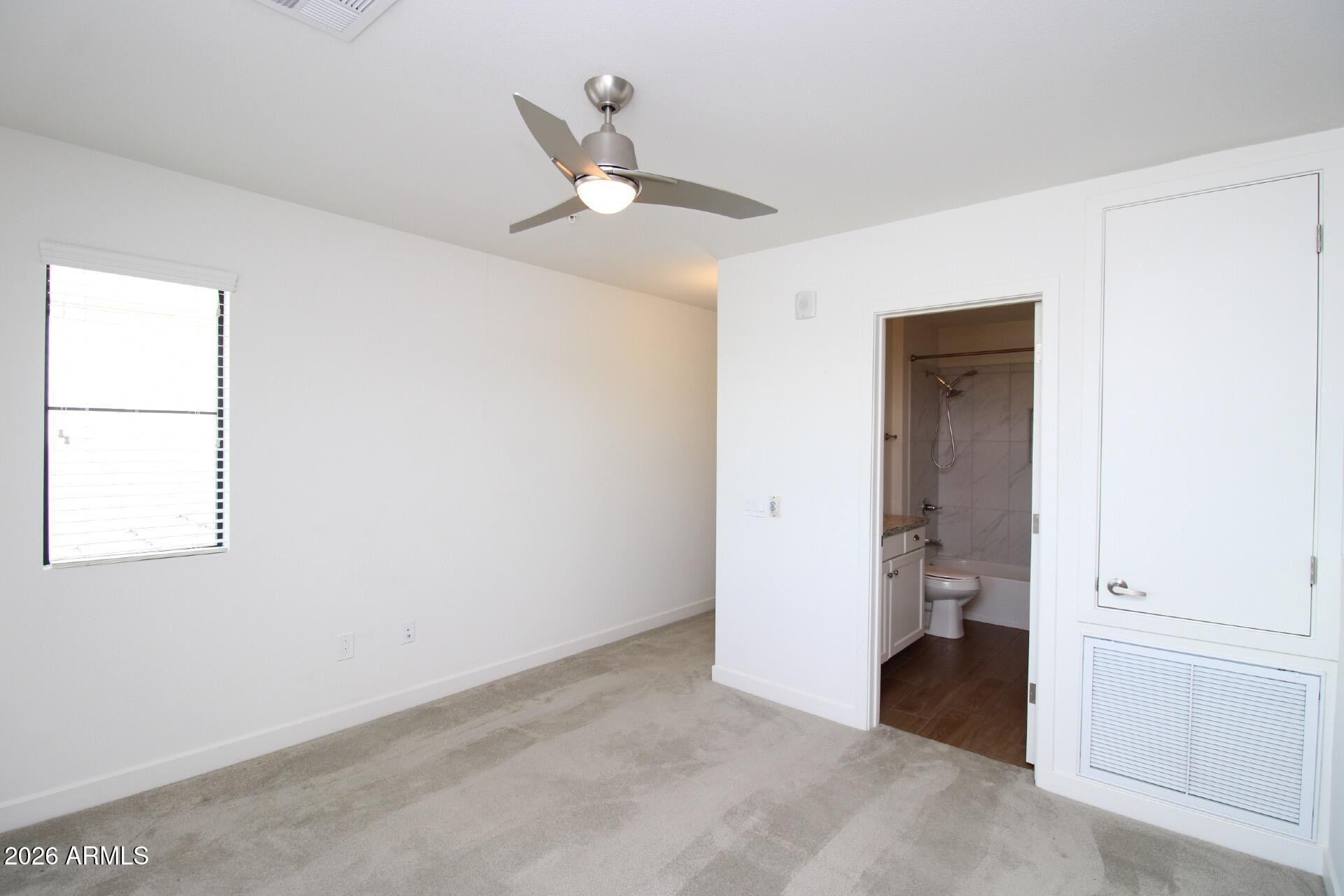 2511 West Queen Creek Road, Unit 438 Chandler, AZ 85248 - Photo 10 of 23 an empty room with a ceiling fan and a window