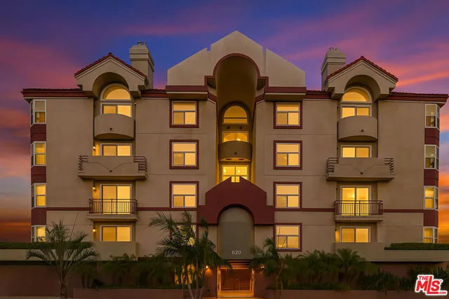 a front view of a residential apartment building with a yard