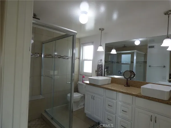 a bathroom with double vanity and a mirror