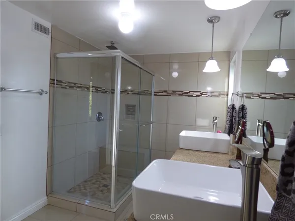 a bathroom with a sink a toilet a mirror and shower