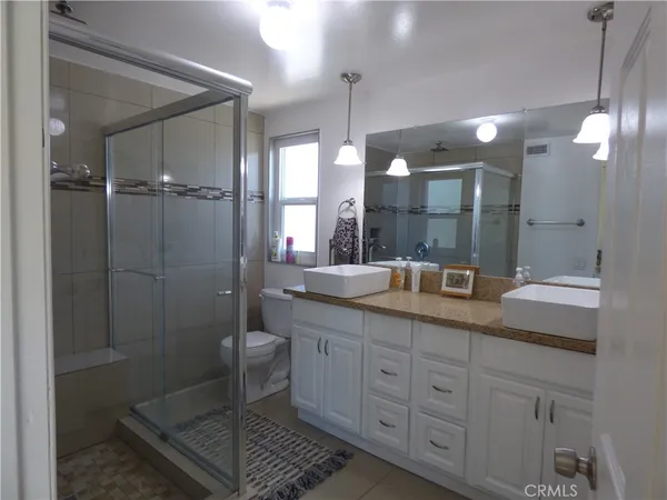 a bathroom with a double vanity sink toilet and shower