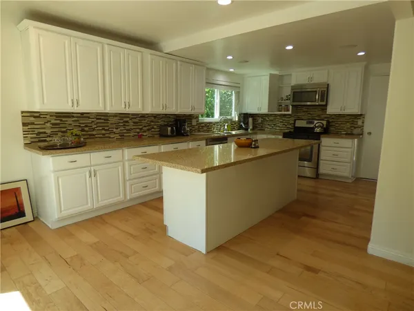 a kitchen with a sink cabinets and wooden floor