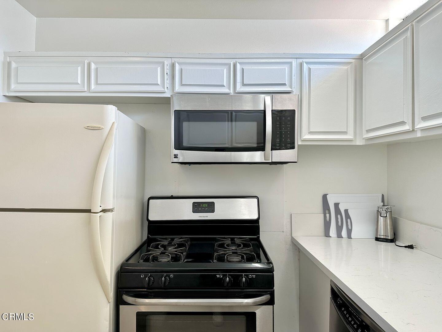 1364 Neptune Square Oxnard, CA 93035 - Photo 20 of 42 a kitchen with stainless steel appliances a white stove top oven and refrigerator