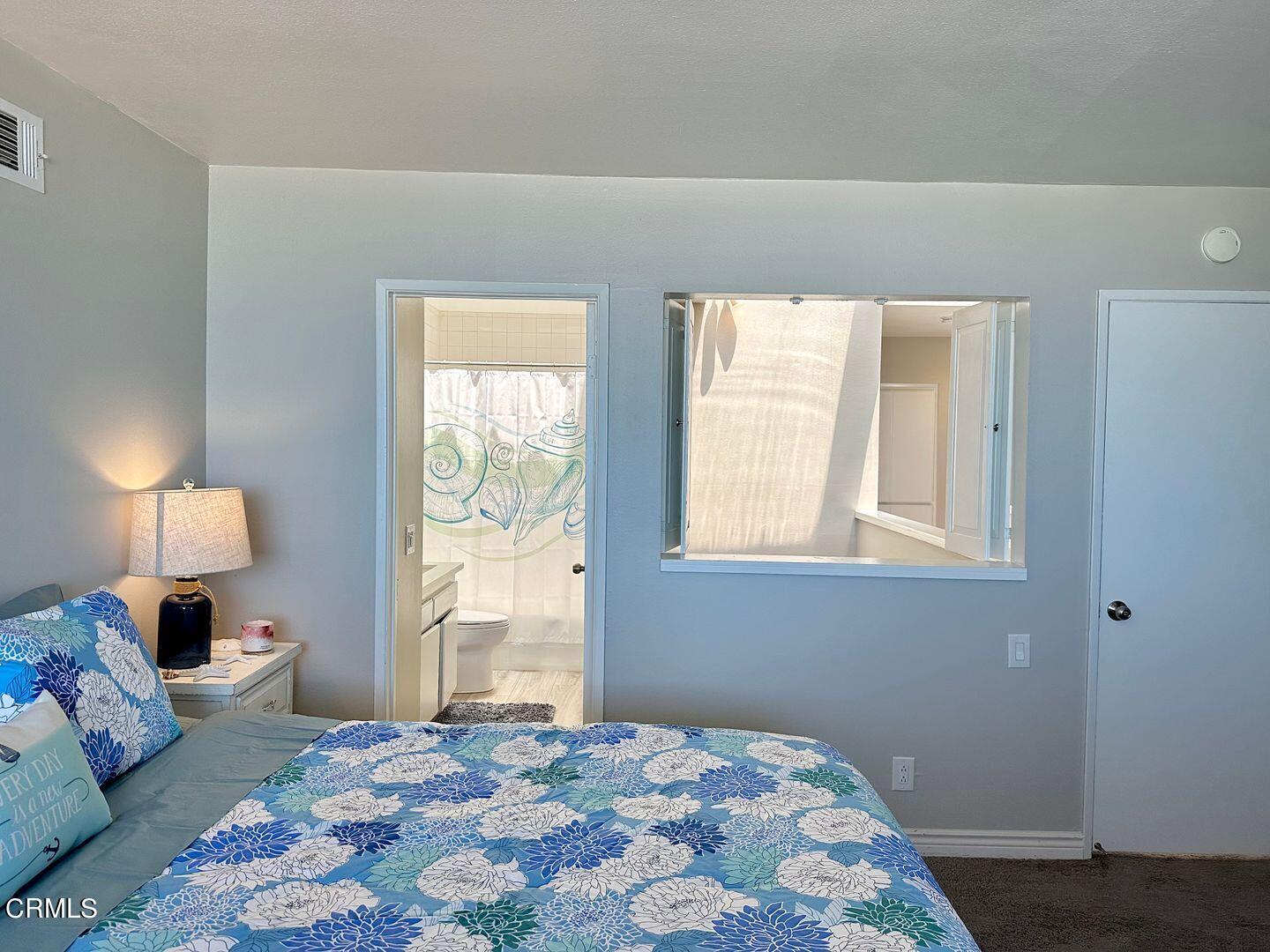 1364 Neptune Square Oxnard, CA 93035 - Photo 29 of 42 a bedroom with a bed and a lamp