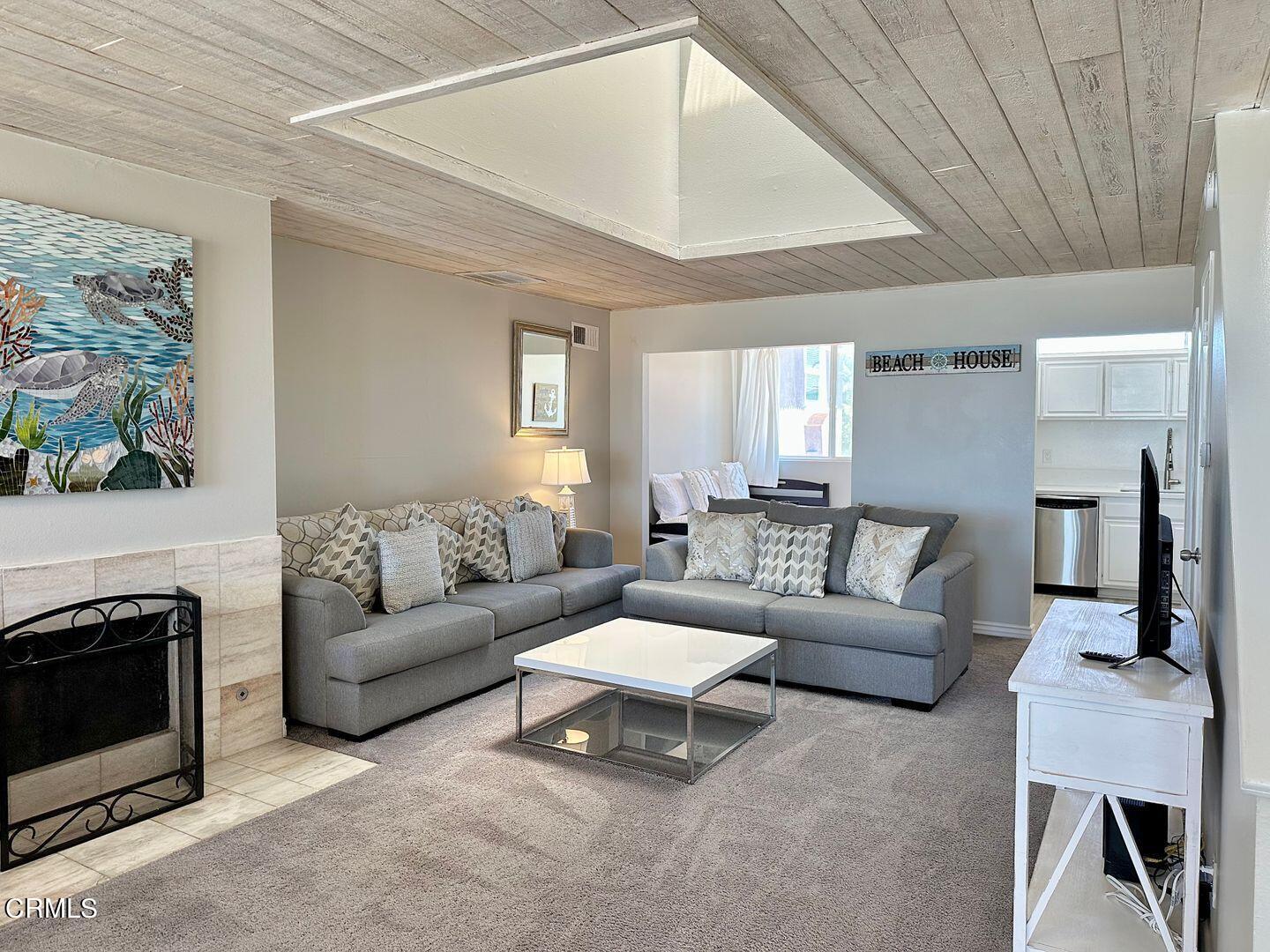 1364 Neptune Square Oxnard, CA 93035 - Photo 9 of 42 a living room with furniture a fireplace and a flat screen tv