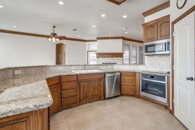 a kitchen with stainless steel appliances granite countertop a sink and a stove