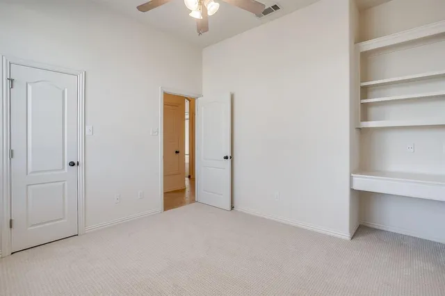 a view of an empty room with a chandelier fan