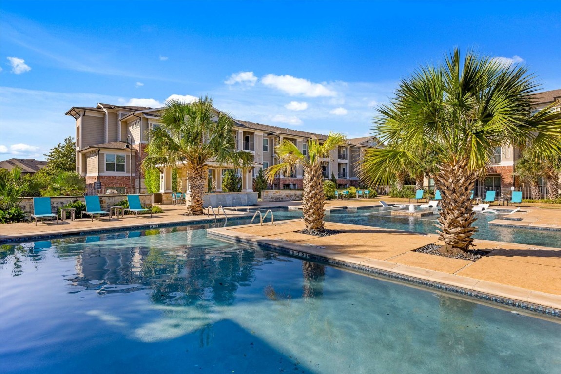9308 South 1st Beach, Unit 623 Austin, TX 78748 - Photo 23 of 23 a view of a swimming pool with lawn chairs under an umbrella