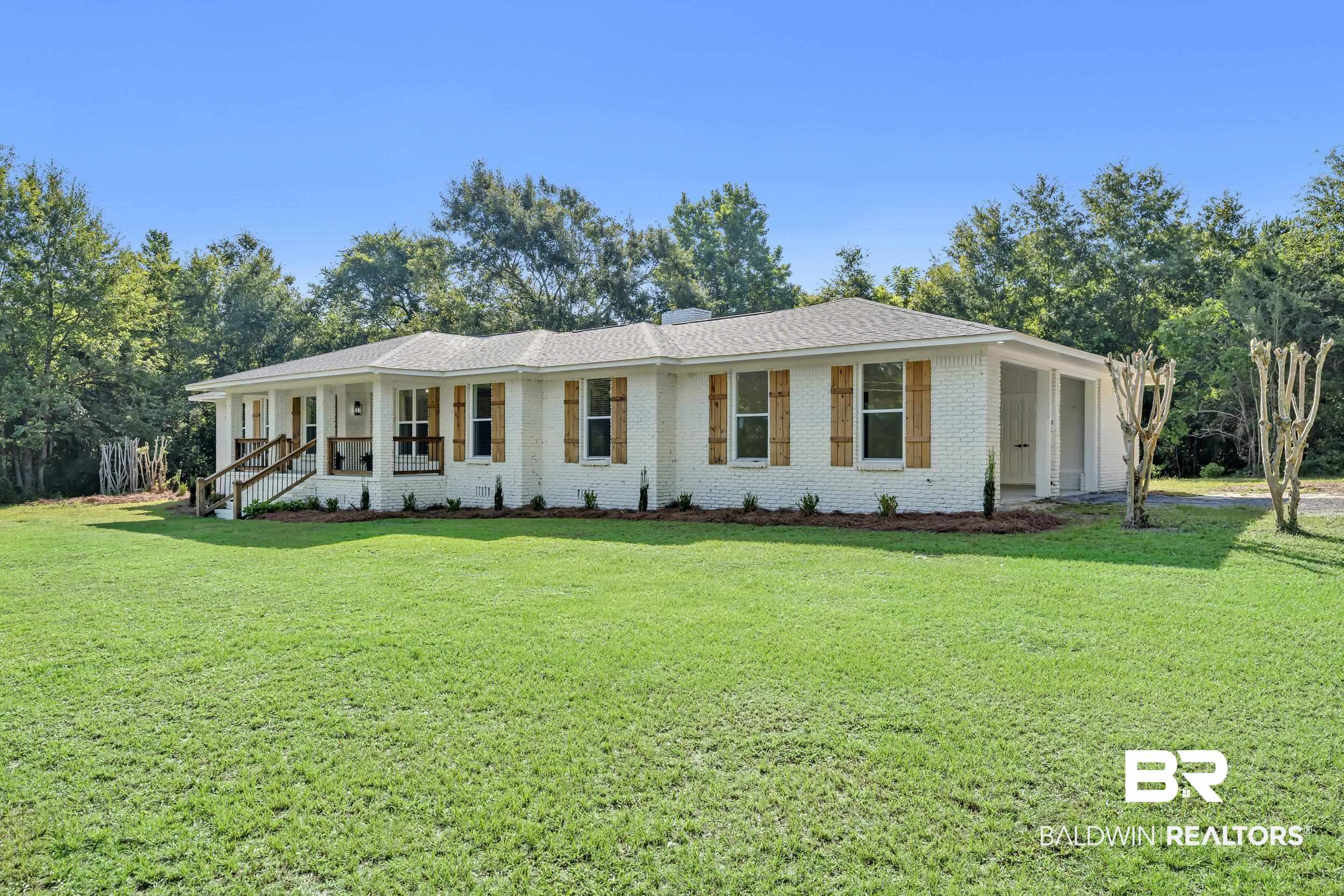 8170 Wilmer Georgetown Road Wilmer, AL 36587 - Photo 2 of 31 White brick exterior with a covered front porch featuring white columns and dark wood railings
