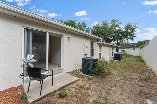 a backyard of a house with table and chairs