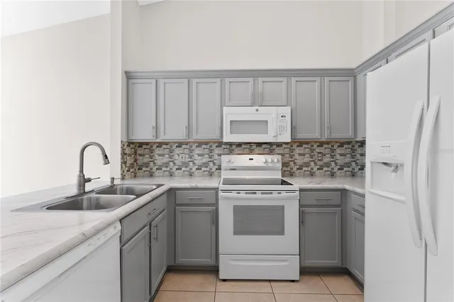 a kitchen with white cabinets appliances and sink