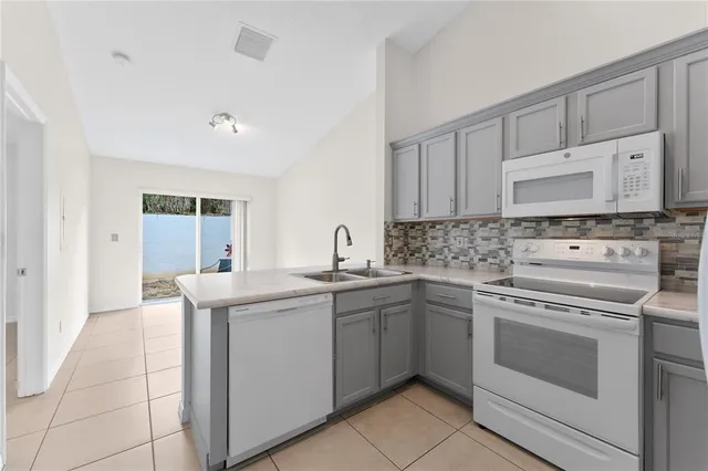 a kitchen with a stove sink and cabinets