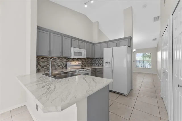 a kitchen with stainless steel appliances granite countertop a refrigerator sink and cabinets