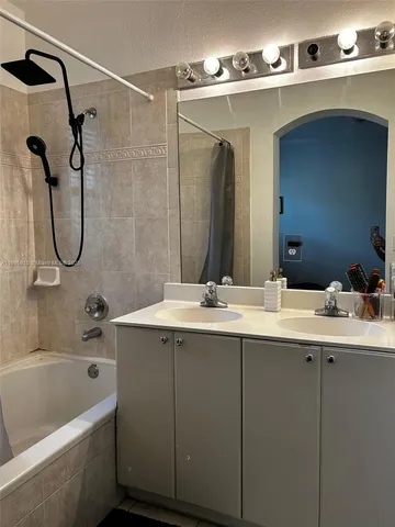 a bathroom with a double vanity sink and a mirror