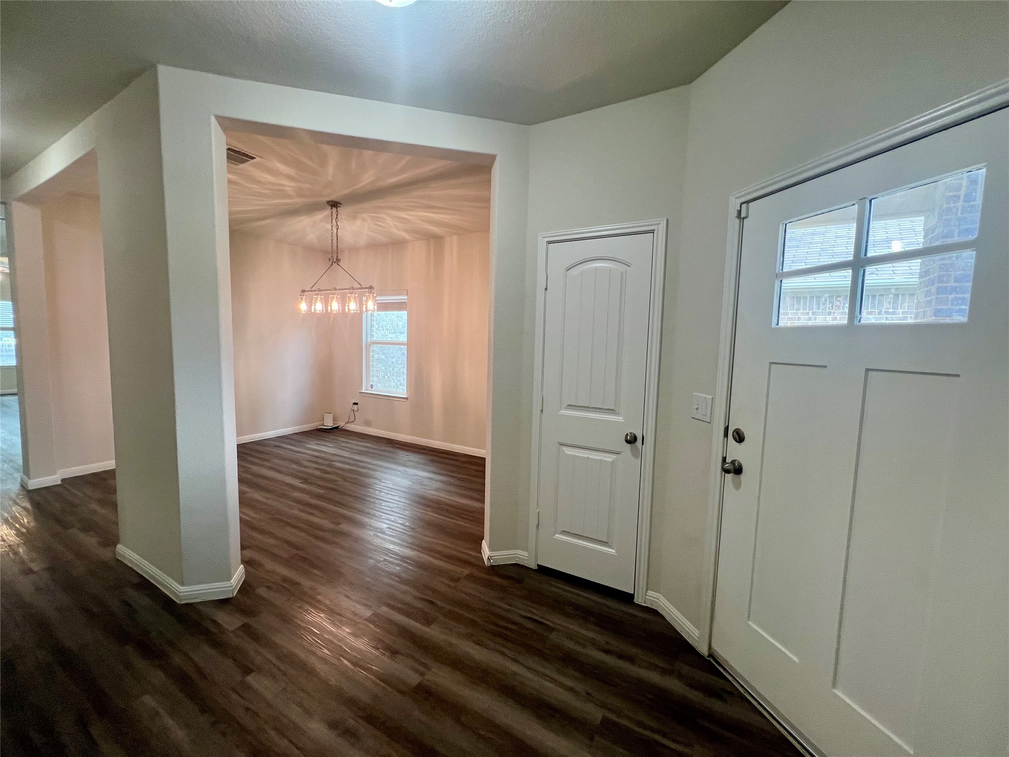 104 Moravia Road Georgetown, TX 78626 - Photo 7 of 36 A welcoming entryway with rich wood-look flooring leads to an inviting dining area, perfect for gatherings.