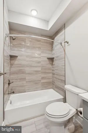 a bathroom with a toilet and a bath tub