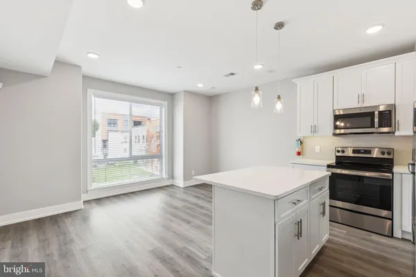a kitchen with stove cabinets and stainless steel appliances