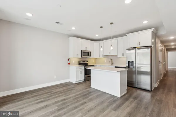 a kitchen with a refrigerator and a stove top oven