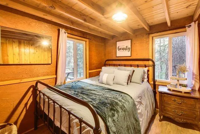 a bedroom with a bed and a large window with the outer view