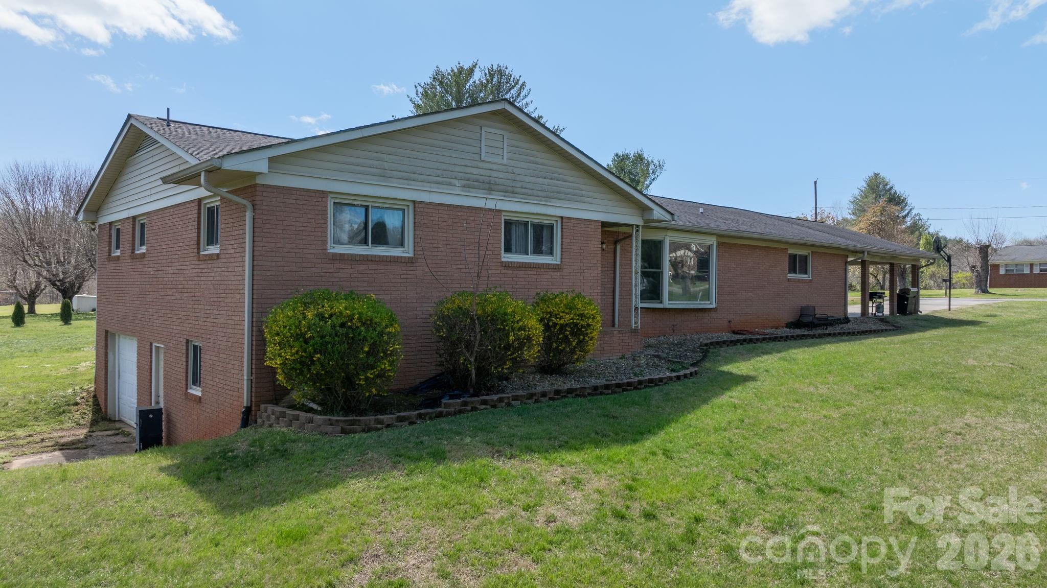 103 Hamp Street Morganton, NC 28655 - Photo 4 of 42 a view of a yard in front of a house with plants and large tree