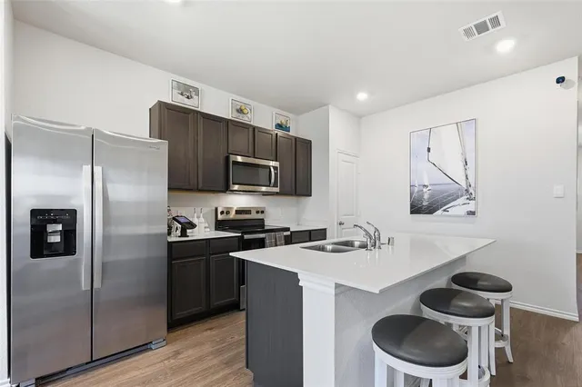 a kitchen with a refrigerator sink and wooden floor