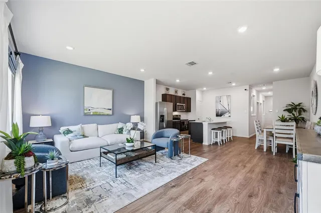 a living room with furniture kitchen view and a potted plant