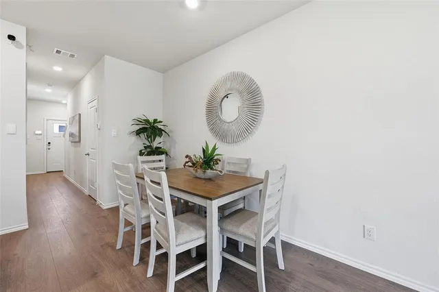 a room with stainless steel appliances a dining table chairs and couches