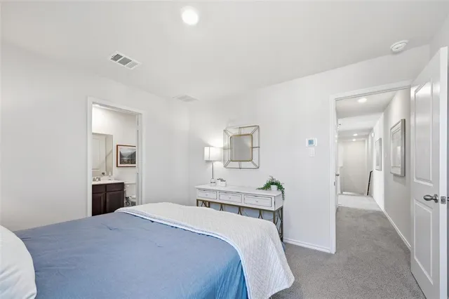 a bedroom with a large bed and a potted plant