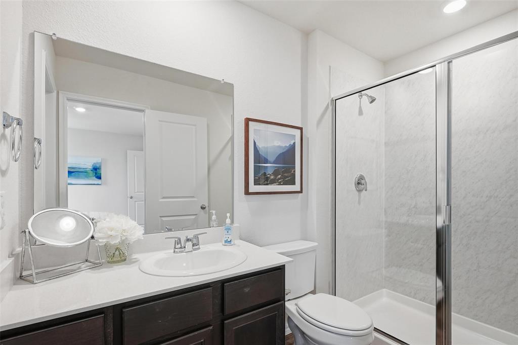 6016 Primrose Road Princeton, TX 75407 - Photo 7 of 23 a bathroom with a toilet a sink and a mirror