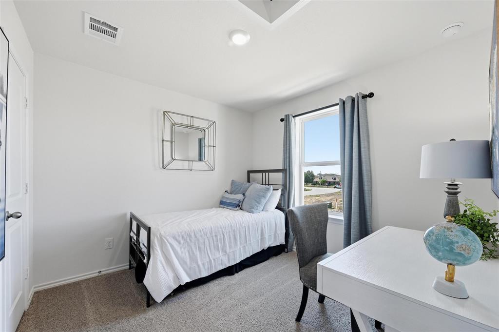 6016 Primrose Road Princeton, TX 75407 - Photo 8 of 23 a bedroom with a bed and a table in it