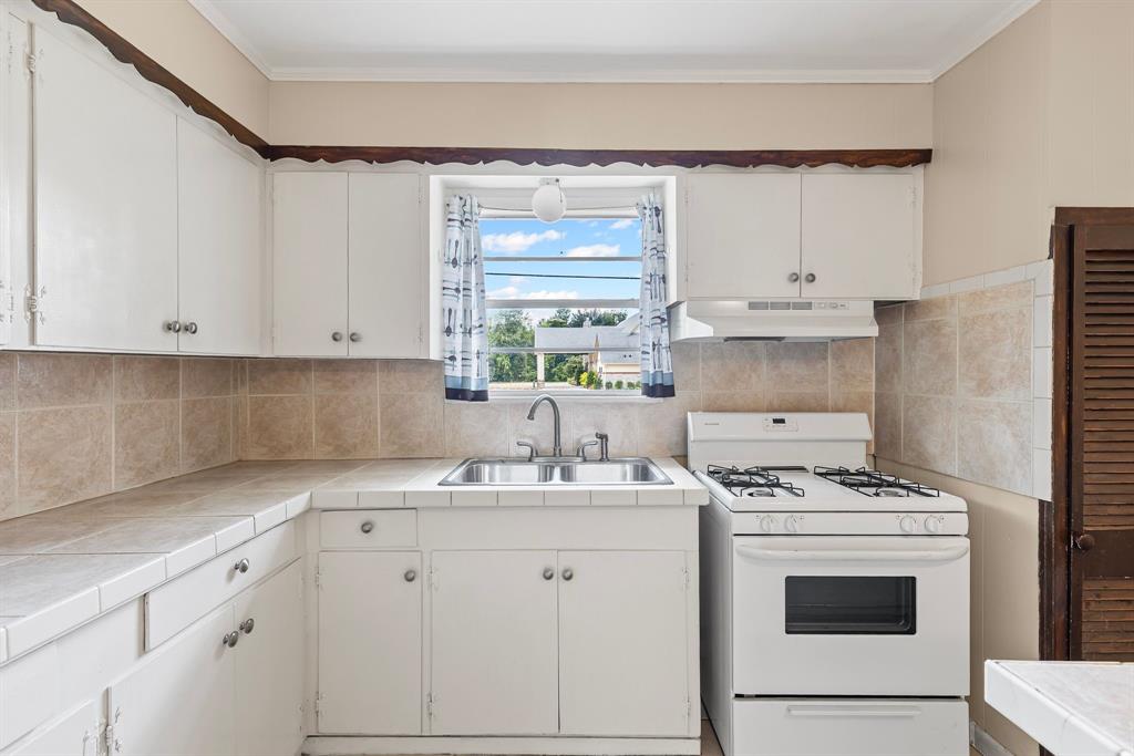 122 Fm 275 Emory, TX 75440 - Photo 13 of 38 a kitchen with granite countertop a sink stove a window and white cabinets