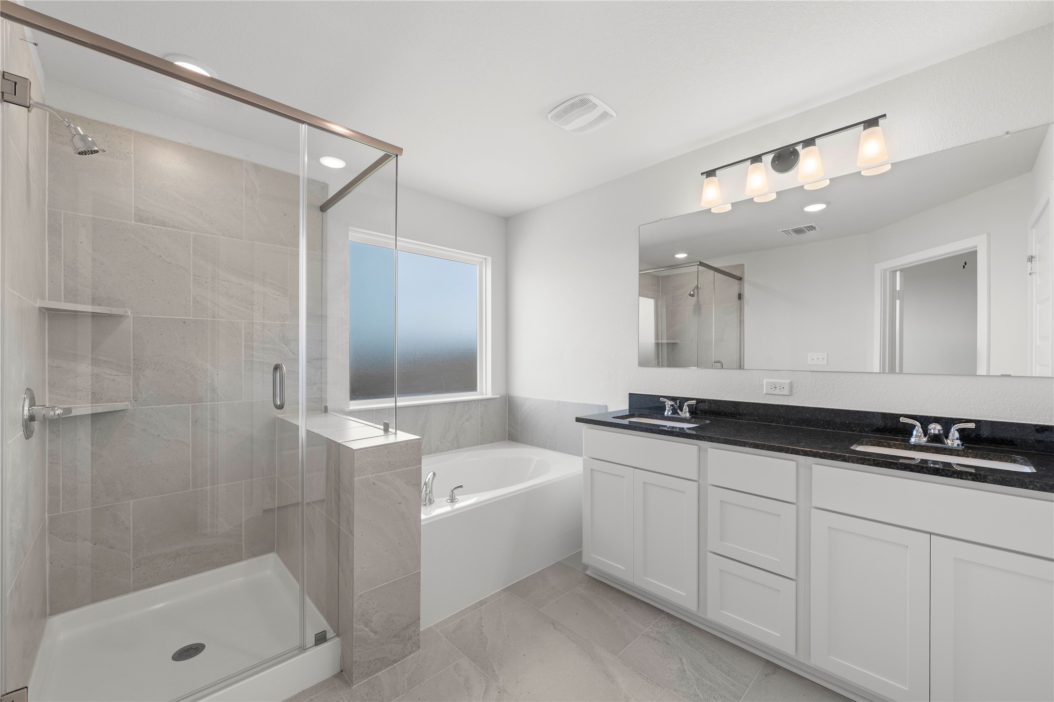 220 Gus Loop Georgetown, TX 78626 - Photo 11 of 18 Luxurious primary bath with a glass-enclosed shower, soaking tub, and a long double vanity.