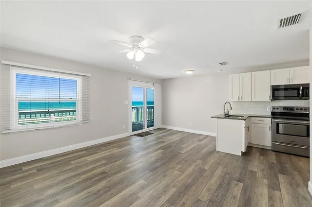 a view of kitchen with granite countertop cabinets and refrigerator